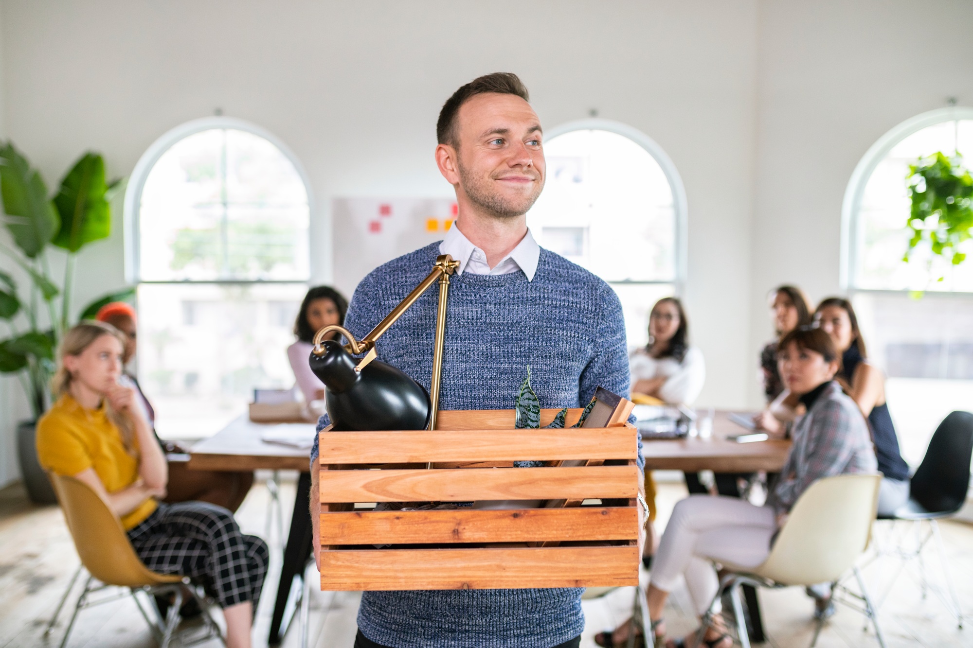 Young businessman leaving office with his personal belongings